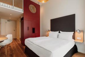 a bedroom with a large white bed and a red wall at Grimm´s Berlin Potsdam in Teltow +73 photos