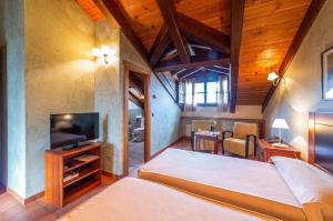 a bedroom with a large bed and a television at Casa de las Paneras in Benavente