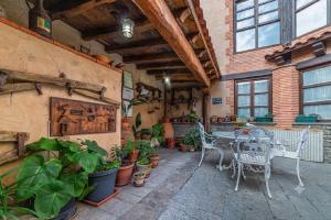 a patio with a table and chairs and potted plants at Casa de las Paneras in Benavente