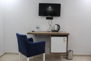 a desk with a tv and two blue chairs at Caretta Vita Bella in Silifke +11 photos
