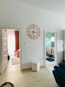 a living room with a large clock on the wall at Debres Apartment Aiud in Aiud +2 photos