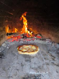 a pizza is cooking in a brick oven at Sárkányszikla Apartman in Nemti