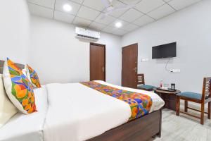 a bedroom with a bed and a tv and a chair at FabHotel Connect in Jaipur