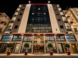 a tall building with potted trees in front of it at Majliss Hotel Downtown in Rabat