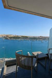 a chair and table on a balcony with a view of the water at Sliema Centric Hotel in Sliema