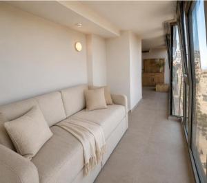 a white couch in a room with a large window at Sliema Centric Hotel in Sliema