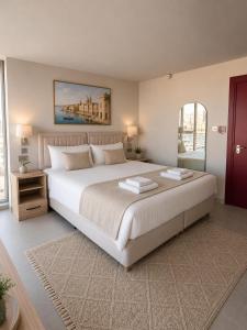 a bedroom with a large bed and a large window at Sliema Centric Hotel in Sliema