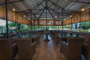a restaurant with tables and chairs in a room at Summit Green Lake Tea Resort & Spa in Jakhalābāndha