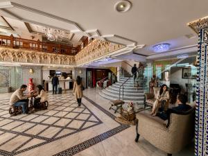 a group of people sitting in chairs in a lobby at Majliss Hotel Downtown in Rabat