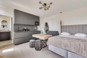 a bedroom with a large bed and a kitchen at Modern Studio 3P - Aubervilliers in Aubervilliers