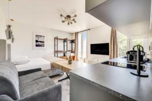 a kitchen and living room with a bed in a room at Modern Studio 3P - Aubervilliers in Aubervilliers