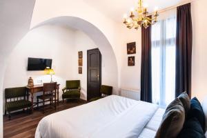 a bedroom with a bed and a table and a desk at Mr Görgey Art Hotel in Visegrád