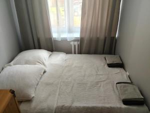 ein Bett in einem kleinen Zimmer mit Fenster in der Unterkunft APT w centrum in Suwałki