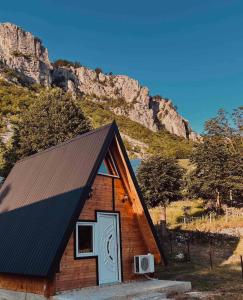 a small cabin with a black roof at Ognjiste Komarnice in Komarnica