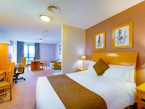 a hotel room with a bed and a desk at Great National South Court Hotel in Limerick +51 photos