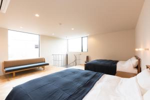葉山町にあるThe Canvas Hayama Park, 葉山のベッド2台とソファが備わるホテルルームです。