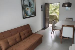 a living room with a couch and a table at Porto bello condomínio in Porto De Galinhas
