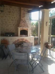 a patio with a table and a brick fireplace at Maisonnette à Coulon in Coulon +2 photos