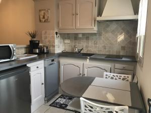 a kitchen with white cabinets and a table at Maisonnette à Coulon in Coulon