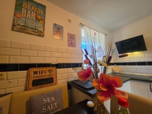 a kitchen with a vase of flowers on a table at Kleine Auszeit in Stolpe auf Usedom