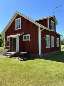 a red barn with a table and chairs in front of it at Örnafälla in Örnafälla