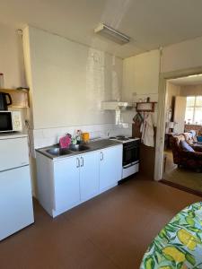 a small kitchen with white cabinets and a sink at Örnafälla in Örnafälla +15 photos