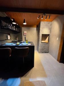 a kitchen with a black counter and a fireplace at Chalé lago Azul in Venda Nova do Imigrante