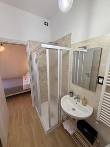 a bathroom with a shower and a sink and a mirror at Agrialloggio Supramonte in Barisciano