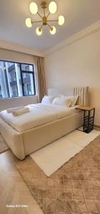 a bedroom with a large bed and a window at Artesano A71 in Nairobi