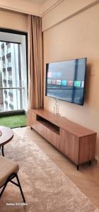 a living room with a large flat screen tv on a wall at Artesano A71 in Nairobi