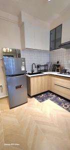a kitchen with a refrigerator and a wooden floor at Artesano A71 in Nairobi
