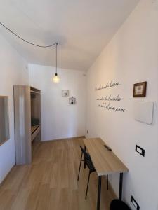 a dining room with a wooden table and a wall with writing at Agrialloggio Supramonte in Barisciano
