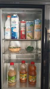 a refrigerator filled with milk and other food items at Piccolo hotel holiday center in Finale Ligure