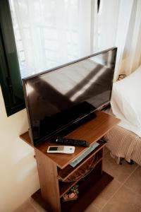 a large flat screen tv on a wooden table at Iris apartment 1 in Anaxos