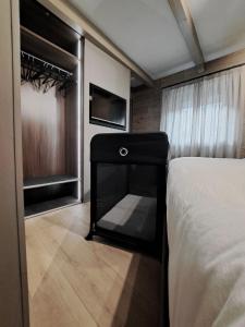 a bedroom with a bed and a tv and a window at VHĀUS Apartment and Spa in Predazzo