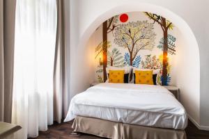 a bedroom with a white bed with a painting on the wall at Mr Görgey Art Hotel in Visegrád