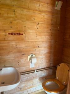 a wooden bathroom with a toilet and a sink at Lystang Camping & Cabins in Notodden +44 photos