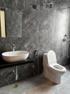 a bathroom with a white toilet and a sink at Bhagwati Hotel And Rooms in Udaipur