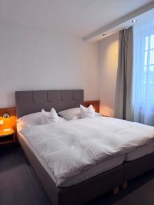 a bedroom with a large white bed with a window at Hotel Lindenhof Kasteel in Mönchengladbach