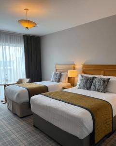 a hotel room with two beds and a table at Fairhill House Hotel in Clonbur