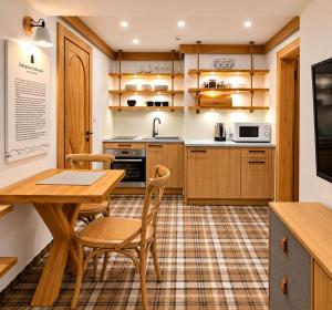 a kitchen with a wooden table and chairs at VisitZakopane - Willa Bajka Apartments in Zakopane