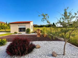 a garden with a statue and a house at La Casa del Roc in Sainte-Colombe
