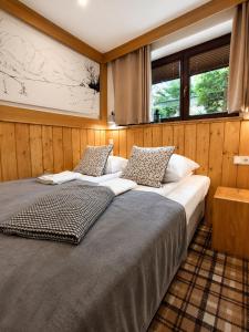 a bedroom with two beds and two windows at VisitZakopane - Willa Bajka Apartments in Zakopane +109 photos