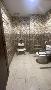 a bathroom with a toilet and a bench in it at اكليل البيت in Al ‘Utaybīyah
