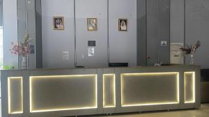 a reception desk with yellow lights in a room at اكليل البيت in Al ‘Utaybīyah