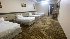 a hotel room with two beds and a couch at اكليل البيت in Al ‘Utaybīyah