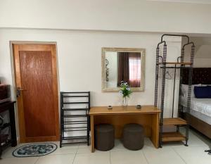 a room with a desk and a bed and a mirror at Nais cottage in Cape Town