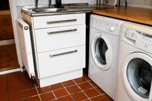 a kitchen with a sink and a washing machine at The Walmer Retreat in Deal