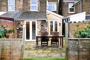 a patio with a table and chairs in front of a house at The Walmer Retreat in Deal