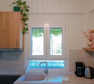 a kitchen with a sink and two windows at Etherio in Makrygialos +18 photos